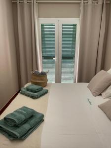 卡兰博希Bonito apartamento con terraza, jardín y piscina的一间卧室配有一张带两张绿毛巾的床