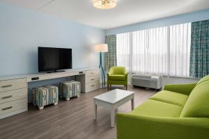 大洋城芬威克酒店 的客厅配有绿色沙发和电视