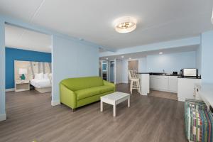 大洋城芬威克酒店 的一间带绿色沙发的客厅和一间厨房