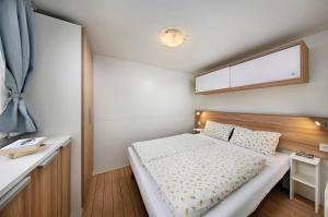 欣费尔德KNAUS Campingpark Hünfeld的一间小卧室,配有一张床和一张书桌