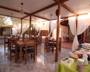 圣佩德罗·德·阿塔卡马Anka Hostel的餐厅设有木桌、椅子和白色窗帘