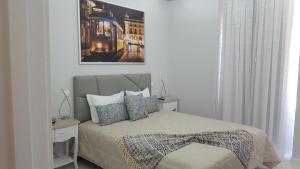 里斯本阿露比雅格兰德盘沙住宅酒店的卧室配有一张床,墙上挂着一幅画