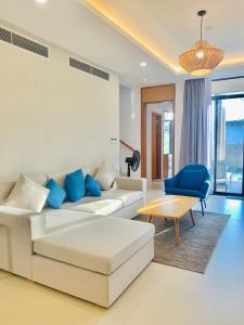 芽庄Cam Ranh Villa的客厅配有白色沙发和蓝色椅子
