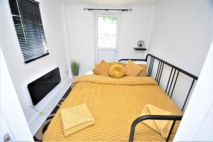 BromleyAdorable 1 bedroom guest house with free parking.的一间卧室配有一张黄色毯子床