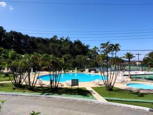 瓜鲁雅Apartamento até 10 pessoas na enseada Guarujá em condomínio clube praia piscinas salão jogos quadra futebol campo parquinho brinquedos Wi-fi Home office的从度假村的阳台上可欣赏到游泳池的景色