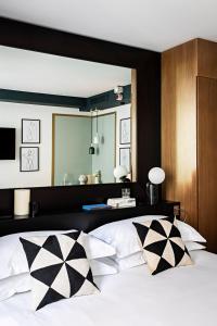 巴黎Holiday Inn Paris Elysées, an IHG Hotel的一间卧室配有一张大床,提供黑白枕头