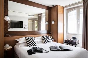巴黎Holiday Inn Paris Elysées, an IHG Hotel的一间卧室配有一张大床,提供黑白枕头