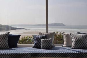 韦德布里奇Gorgeous Apartment only yards from Polzeath Beach的配有枕头的沙发,享有海滩美景
