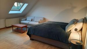 Sint-Pieters-LeeuwThe Kettle House - Manor的一间卧室配有一张床、一把椅子和一张沙发