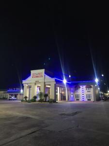 橙县最佳价格套房汽车旅馆的夜间停车场里灯亮的建筑物