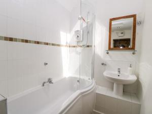 NymphsfieldTump Cottage的白色的浴室设有水槽、浴缸和镜子