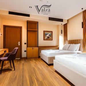 伏罗拉Valza Boutique Hotel的酒店客房配有两张床和一张书桌
