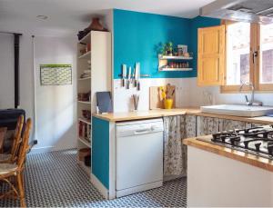 科贝拉罗布里加casa mediterrània a la vora de Barcelona的厨房设有蓝色的墙壁和炉灶烤箱。