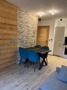 莫尔济讷CARLINA 105的一间带木桌和蓝色椅子的用餐室