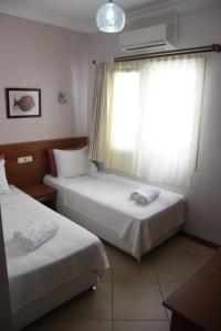 博德鲁姆Mia Butik Hotel Bodrum的酒店客房设有两张床和窗户。