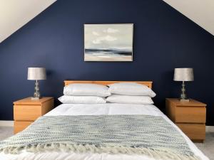 亚历山德里亚Light & Spacious Loch Lomond Apartment的一间蓝色卧室,配有带2个床头柜的床