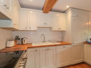 ChiselboroughGreenham Rise的厨房配有白色橱柜和水槽