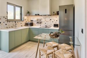 卡拉马孔Nomas Living的厨房配有绿色橱柜和玻璃桌