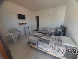 巴纳伊巴Pousada Progresso的一间卧室配有两张床和电视。