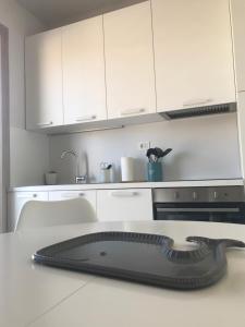 雷卡纳蒂港SeSil Amare的厨房配有白色橱柜和台面上的黑色用具