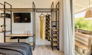 卡拉马孔Nomas Living的一间卧室,配有衣柜和架子上的连衣裙