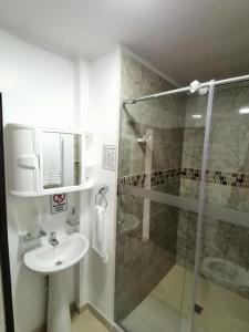 圣安德烈斯Hostal Raatid Manchy的一间带水槽和玻璃淋浴的浴室