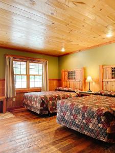 MercerCranberry Inn的一间卧室设有两张床和木制天花板