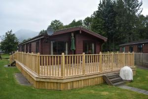 格拉斯哥Lodge at Loch Lomond的小木屋四周环绕着木栅栏