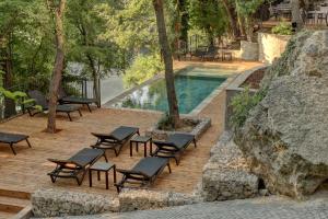 金沙Umani Hotel - Free Beach - Free Parking的一组椅子坐在泳池旁的木甲板上