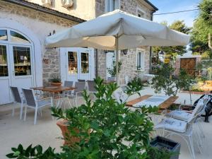 特里班Boutique Vila Marijini Dvori的庭院配有遮阳伞和桌椅。