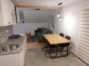 兹拉蒂博尔Apartmani Eho Zlatibor的厨房以及带桌子和沙发的用餐室。