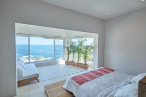 Playa EstacahuiteCasa Roni - 5 Bedroom Luxury Villa with Ocean View的一间卧室设有一张床和一个海景大窗户