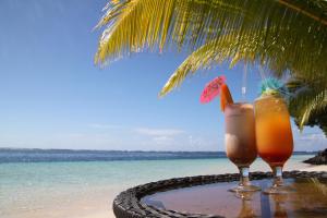 Manase史蒂文森马纳塞酒店的坐在海滩上桌边的2杯鸡尾酒