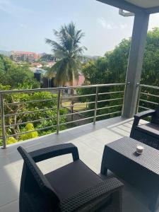 格罗斯岛Belle Luxury Apartments的阳台配有桌椅和棕榈树。