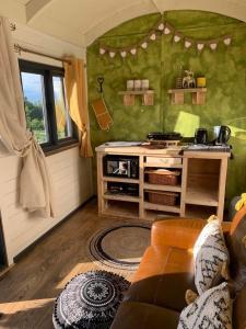 特伦特河畔斯托克Rhodes To Serenity - Mermaid Shepherds Hut的一间带炉灶的厨房和一张沙发