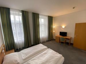 维也纳Kolbeck Rooms的卧室配有一张床、一张书桌和窗户。