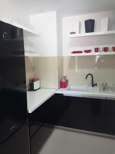 布德瓦Red Lux的厨房配有黑色橱柜和水槽