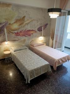 萨沃纳La Casa di Noemi的一间设有两张床的客房,墙上挂着壁画