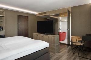 图尔库图尔库滨海皇宫丽笙布鲁酒店的一间卧室配有一张床和一台平面电视