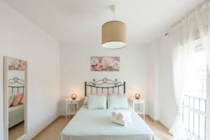 托罗克斯科斯塔Apartamento Coral的白色的卧室设有床和窗户