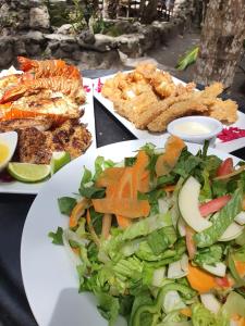 圣佩德罗Bella Vista Resort Belize的餐桌,上面有蔬菜和其他食物的盘子