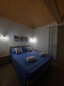 法维尼亚纳TURISMO EGADI - CHARME的一间卧室配有蓝色的床和2条毛巾