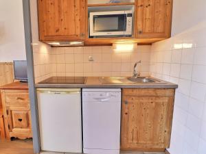 谷雪维尔Appartement La Tania, 2 pièces, 4 personnes - FR-1-182A-21的厨房配有白色洗碗机和微波炉