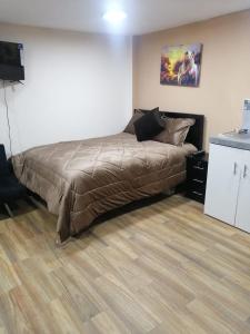 基多FAKALI Homestay的一间卧室配有一张床,铺有木地板
