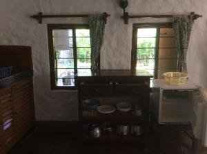 迪亚尼海滩迪亚尼班达旅馆的厨房设有2扇窗户和台面