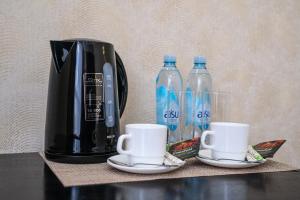 阿斯塔纳Belon Lux Hotel的咖啡壶和桌子上的两瓶水