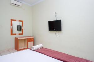 ParepareUrbanview Hotel Platinum Parepare的卧室配有一张床,墙上配有电视。