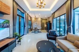 华欣KIN Pool Villa - Hua Hin的客厅配有沙发和桌子