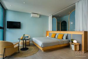 岘港Bare Han - Bare Boutique Stays的一间卧室配有一张带黄色枕头和桌子的床