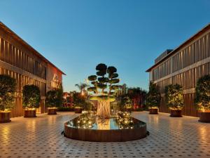 阿拉恰特Biblos Resort Alaçatı的庭院里的一个大型喷泉,有树